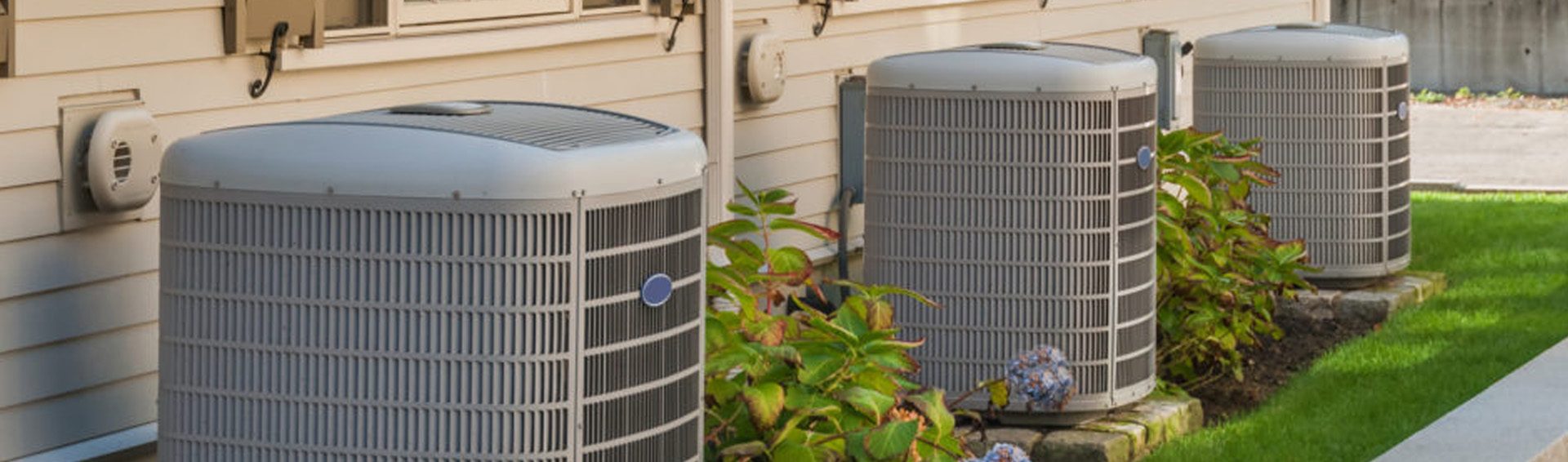 Air conditioner condensers along the side of a house